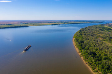 A barge or dry cargo ship goes upstream of the Volga River near Astrakhan. Aerial photography. High quality photo