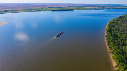 A barge or dry cargo ship goes upstream of the Volga River near Astrakhan. Aerial photography. High...