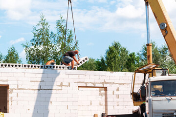 Builder worker installing concrete floor slab panel at building construction site