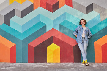 Happy woman leaning on colorful wall