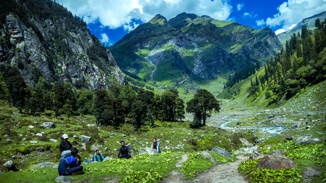 hiker in the mountains. The beautiful stream flowing among the litigants, alpine valley on a trek to Hamta Pass, 4270 m on the Pir Panjal range in the Himalayas.