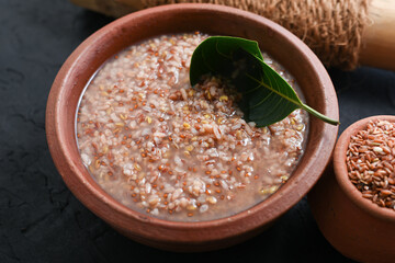 Ayurvedic porridge, Karkidaka Kanji herbal gruel in clay pot black background Kerala South India....