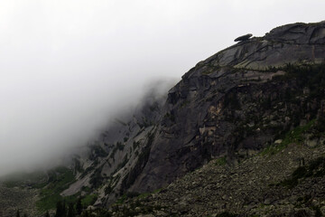 Mountains in the fog. The top of the Sayan mountains. Ergaki national reserve. Beautiful mountain landscape.