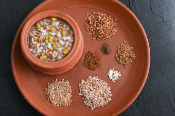 Ayurvedic porridge, Karkidaka Kanji herbal gruel in clay pot black background Kerala South India....