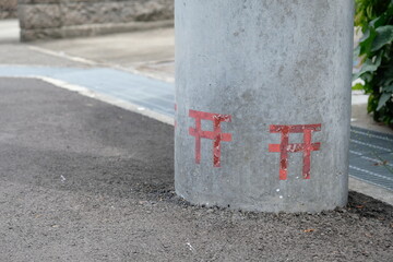 Torii gate painted at the base of a telephone pole. This is no standing urine mark in Japan.