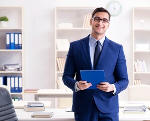 Young handsome businessman employee working in office at desk