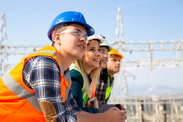 Group portrait of young workers in electric power station 