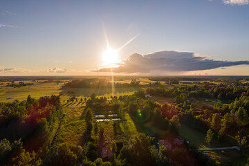 Beautiful sunset over the small town. Fields and trees around. Aerial photography.