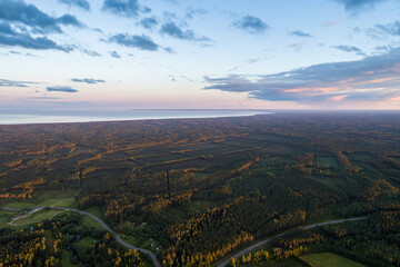 Beautiful sunset over the small town. Fields and trees around. Aerial photography.