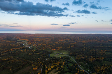 Beautiful sunset over the small town. Fields and trees around. Aerial photography.
