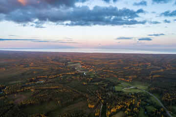 Beautiful sunset over the small town. Fields and trees around. Aerial photography.