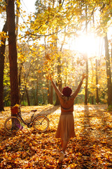 Нappy young woman having fun with leaves in autumn park. 