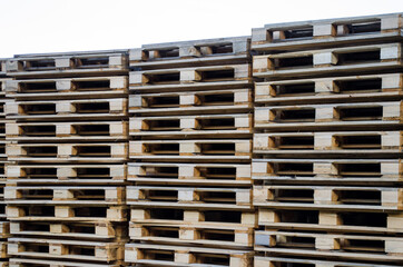 Stacks of wooden pallets for the industrial transportation by trucks or for processing into furniture