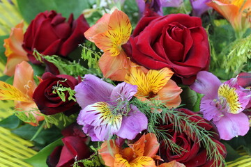 bouquet of colorful flowers with red  roses and alstroemeria on background