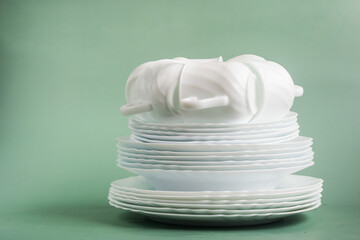table set of white porcelain dishes on a green background