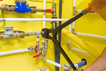 Worker connecting alupex pipes with a tap. Hand press for water pipes PEX - AL - PE-X. plumbing...