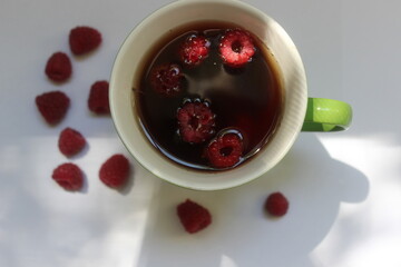 Morning cup of tea with berries on white background