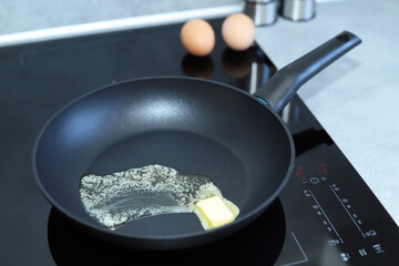 Frying pan and eggs on induction cooker.