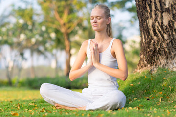 Fototapeta premium Serene calm female adult practicing meditation and yoga at peace outside in the nature. Health, wellness and self care.