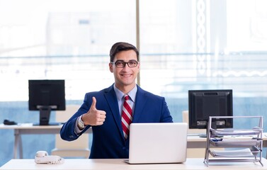 Young handsome businessman employee working in office at desk