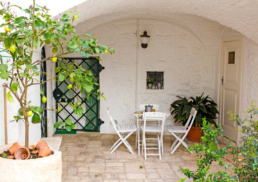 Cozy patio under a stone vault with potted plants and garden furniture in Locorotondo town, Apulia, southern Italy 