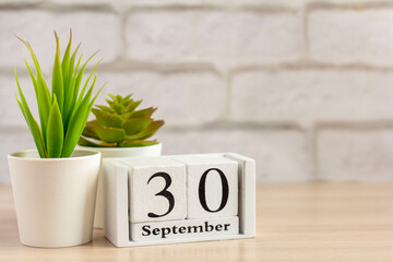 September 30 on a wooden calendar on a table or shelf.One day of the autumn month.Calendar for September. Autumn