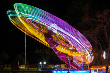 NIN, CROATIA -JULY.23.2020-Abstract, long exposure shot of spinning Children's vintage Carousel at an amusement park in the evening and night illumination