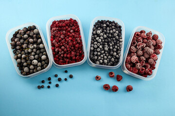 Frozen berries: blueberries, cranberries, raspberries and black currant on a blue background.