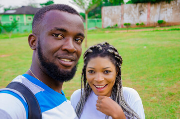 Fototapeta premium two cute african couples feeling excited as they are taking selfie with their smartphone