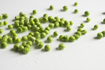 Fresh young green peas close up on white background