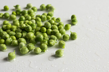 Fresh young green peas close up on white background