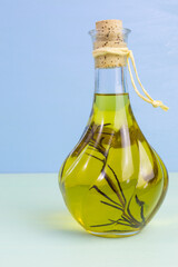 glass bottle of olive oil with a sprig of rosemary