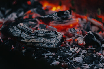 Red hot coals, lit a fire to cook a barbecue. Texture fire bonfire embers.The hot embers of burning wood log fire. Firewood burning on grill.