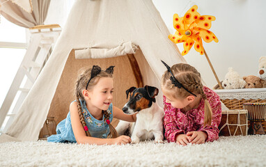 Children lying with dog in wigwam © tan4ikk