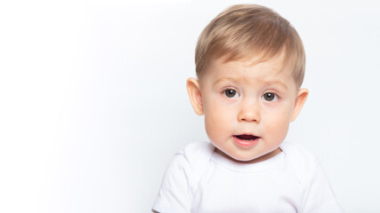 Caucasian baby boy gnaws wooden teethers on white background.