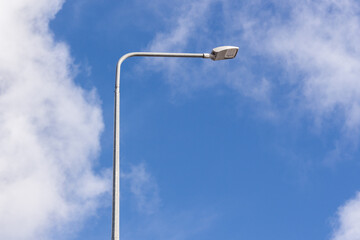 Electric street lamp with blue sky at the background from the bottom view