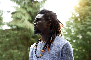 portrait of handsome African American black man with dreadlocks. guy looks side, outdoors