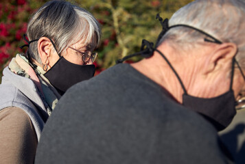 Active senior couple on outdoor walk wearing face masks