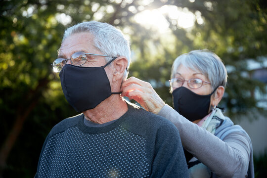 Active senior couple on outdoor walk wearing face masks
