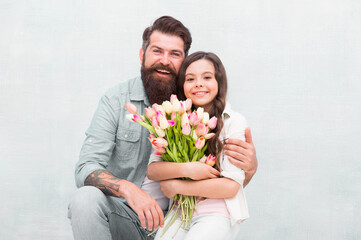 Happy childrens day. Happy family celebrate childrens day. Father embrace little daughter holding flowers. Bearded man and small child. Holiday celebration. International childrens day