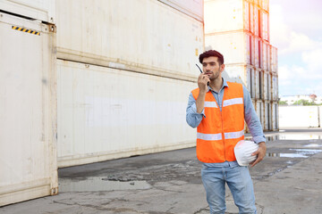 A engineering working at container stock yard, radio mobile talking communication with loader forklift for transport control handling