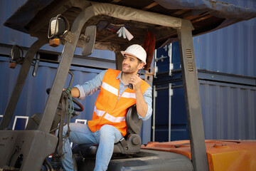 Fototapeta na wymiar A engineering or foreman or driver working at container stock yard with drive a loader forklift steering wheel control for transport handling