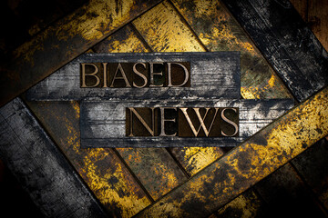 Biased News text formed with real authentic typeset letters on vintage textured silver grunge...