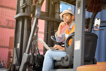 Fototapeta na wymiar A engineering or technician is working at container stock yard, radio mobile talking communication with loader forklift for transport handling inspection check or maintenance