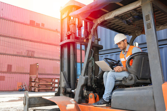 A engineering or technician is working at container stock yard, radio mobile talking communication with loader forklift for transport handling inspection check or maintenance