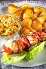 Shish kebab served with roasted potatoes and salad.