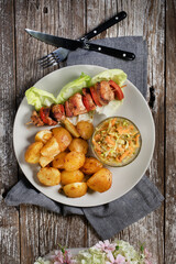 Shish kebab served with roasted potatoes and salad.