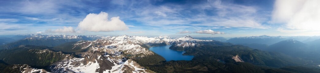 Obraz na płótnie Canvas Aerial Panoramic View of Garibaldi surrounded by Beautiful Canadian Mountain Landscape during a sunny and cloudy day. Taken near Squamish and Whistler, North of Vancouver, British Columbia, Canada.