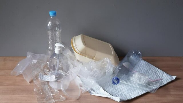 household plastic waste - stop motion animation - heap of domestic plastic trash such as bottles bags containers and packaging material