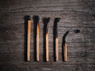Different stages of match burning. Burnt matches isolated on wood background. Creative background